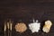 Wheat ears, grains, flour and sliced bread on a dark wooden table