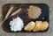 Wheat ears, grains, flour and sliced bread on a kitchen board on a sacking background