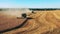 Wheat field with agricultural machines cutting crops