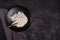 Wheat flour in a black plate on a dark background. The ingredient. Bakery products