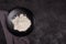 Wheat flour in a black plate on a dark background. The ingredient. Bakery products.