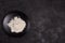 Wheat flour in a black plate on a dark background. The ingredient. Bakery products.