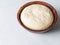 Wheat flour yeast dough in wooden bowl. Copy space