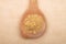 Wheat germs on wooden spoon on brown background