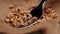 Wheat grains falling into a cracked rustic wooden bowl with a fork.