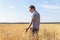 Wheat grains in a farmer`s hands on the wheat field background. ripe ear in a man`s hand. Cereal harvesting