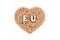 Wheat grains lie in a heart-shaped plate. EU of wooden letters on the grain. Isolated on white. The concept of import and export,