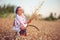 Wheat harvest and proud bulgarian girl working on a field in traditional ethnic folklore dress and sickle.Bulgaria.