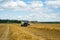 Wheat harvesting by farmers using tractors and combines