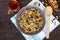 Wheat porridge with nuts, dried berries, raisins, poppies in a ceramic bowl