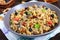 Wheat porridge with nuts, dried berries, raisins, poppies in a ceramic bowl