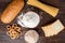 Wheat products on dark wooden background. Bread, spaghetti, wheat flour and flakes, loaf and dryings.