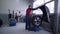 Wheel balancing, professional mechanic male repairs car wheel in auto workshop