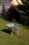 Wheel barrow on the grass in the garden with rake and hoe in front of romantic half timbered house with thatch roof