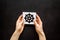 Wheel of dharma - Buddhist religion symbol - in hands on black table top view