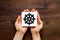 Wheel of dharma - Buddhist religion symbol - in hands on wooden table top view