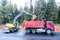 The wheel excavator loads the earth with a bucket to the body of a multi-ton dump truck on the construction site