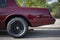 wheel and exhaust pipe of a classic maroon car