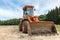 Wheel loader with backhoe standing outdoors