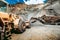 Wheel loader excavator bulldozer with backhoe loading gravel at construction site