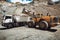 Wheel loader loading gravel and sand into dumper trucks. Machinery and transportation details