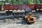 Wheel loader loads gravel into a dump truck at a cargo railway station.