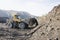 Wheel loader in a mountainous area in an industrial area where minerals are mined.