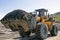 Wheel loader at work. It transports gold-bearing mountain soil to the hopper of the washing device. The gold mining industry