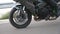 Wheel of modern sport motorbike riding fast at highway. Motorcycle driving at asphalt route. Motor bike racing on