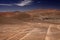 Wheel tracks in red barren waste landscape in the middle of nowhere of Atacama desert, Chile