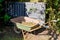 Wheelbarrow and compost bin in the home garden in sunny day