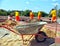 Wheelbarrow with concrete on a construction site, workers in uniform.