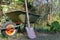 Wheelbarrow filled with leaves and branches with a fanned spade after gardening in spring