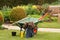 Wheelbarrow with jackets and bottle of drink