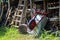 Wheelbarrow leaning overhead on a shed with messy stacked wood