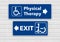 A wheelchair accessible sign points the way to physical therapy and pointing the other way toward the exit is a person standing