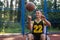 Wheelchair basketball player holding, disability, outdoor basketball court.