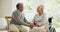 Wheelchair, senior couple and love with conversation in a retirement home with support and holding hands. Happy and