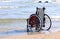 Wheelchair on the shore by the sea
