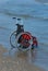 Wheelchair on the shore by the sea on a hot sunny summer day