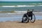 Wheelchair stands on the seashore