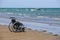 Wheelchair stands on the seashore