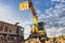 A wheeled excavator loads a dump truck with soil and sand. An excavator with a high-raised bucket against a cloudy sky View from