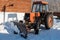Wheeled snow plow tractor with blade in winter