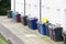 Wheelie bin colour blue, purple and black for refuge collection outside house in a row