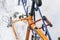 Wheelless orange bicycle strapped to the iron fence