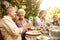 Where theres family theres food. a family eating lunch together outdoors.