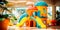 Whimsical and colorful children\\\'s play area in a hotel lobby with interactive games and toys