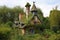 a whimsical cottage with a tall chimney, surrounded by greenery and birds