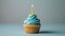 Whimsical cupcake with blue pastel frosting and a single candle, generative ai